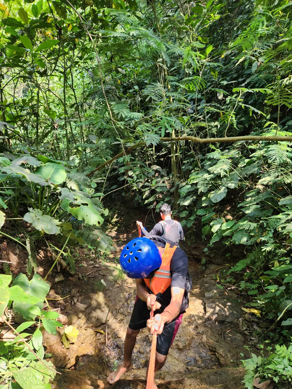 Curug Naga: peserta trekking di hutan tropis dengan helm dan pelampung